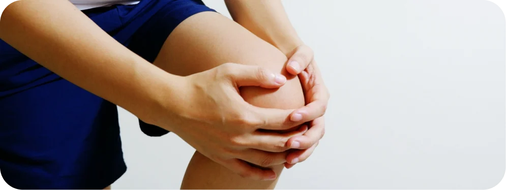 Person holding knee with pain, illustrating symptoms of meniscus extrusion and joint inflammation