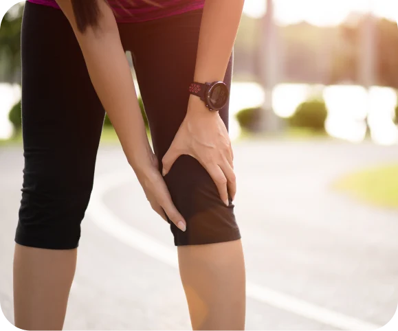 Person holding their knee due to pain and instability, illustrating common symptoms of Posterolateral Corner (PLC) and MCL injuries