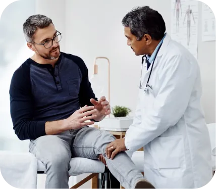 Orthopedic doctor examining a patient’s knee during evaluation and treatment planning for chronic patellar fat pad inflammation
