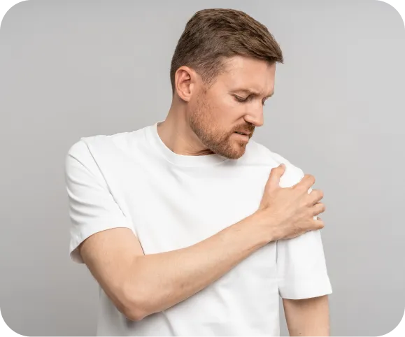 Man holding his shoulder due to pain, illustrating common symptoms of rotator cuff partial thickness tears, PASTA tears, RTC tendinosis, and calcific tendinitis
