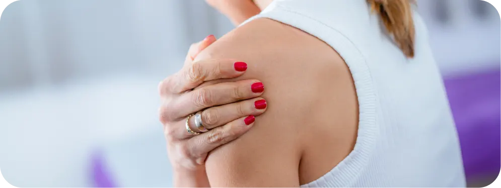 Close-up of a woman holding her painful shoulder, illustrating common symptoms of a SLAP lesion and labrum irritation